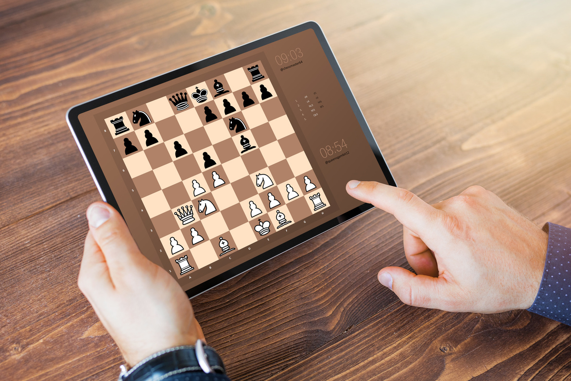Person Playing Chess Online on Tablet Computer